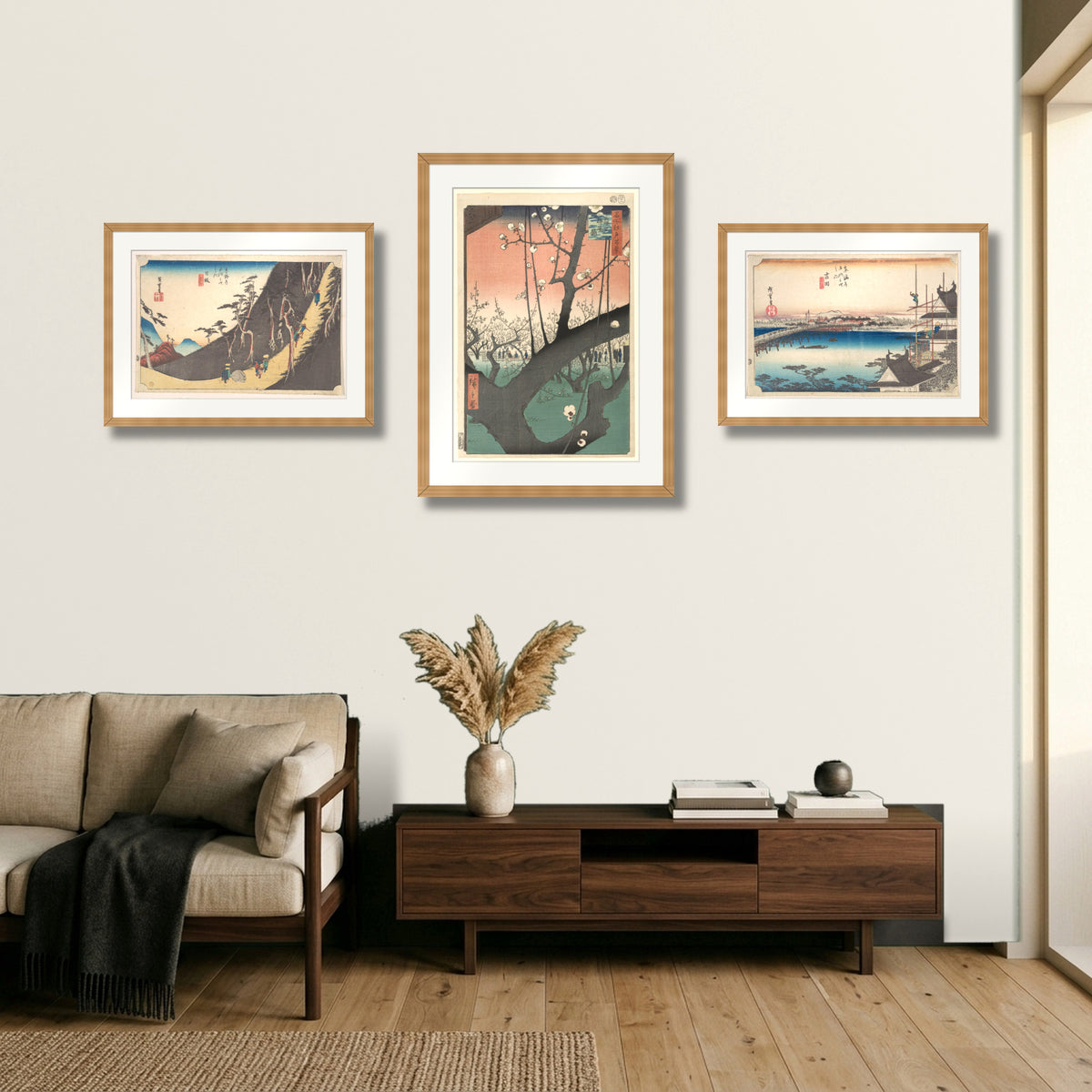 Edo Spring Triptych – Nissaka, Plum Garden at Kameido and Yoshida Bridge by Utagawa Hiroshige, three framed prints above a credenza